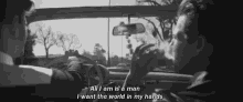 a black and white photo of two men in a car with the caption all i am is a man