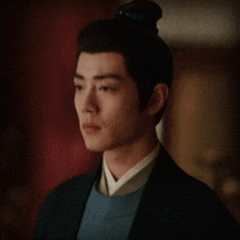a man with a bun on his head looks to the side
