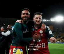 two soccer players are posing for a picture and one of their shirts says ettigoat on it