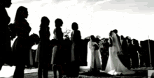 a black and white photo of a bride and groom and their bridal party