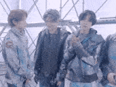 a group of young men are standing next to each other in a room with scaffolding in the background .