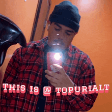 a man in a plaid shirt is taking a selfie with the words this is a topuriali