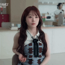 a woman with long red hair is sitting in a chair in front of a kitchen with the words family cooking day written above her
