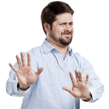 a man with a beard is making a stop gesture with his hands