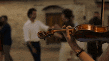 a man is playing a violin in front of a crowd of people