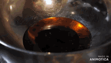 a close up of a liquid in a bowl with the words made in animatica