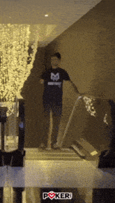 a man wearing a black shirt with the letter m on it is walking down stairs