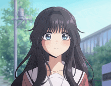 a girl with long black hair and blue eyes is looking at something