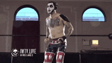 a wrestler stands in a ring with the words iwtv live on the bottom