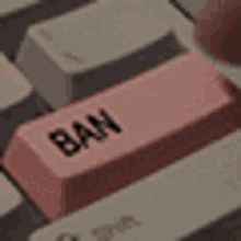 a close up of a pink ban key on a computer keyboard .