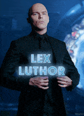 a man in a suit and tie is standing in front of a sign that reads lex luthor