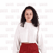 a woman in a white shirt is dancing in front of a wall that says tanzschule weiss