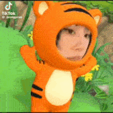 a person is wearing a tiger costume with their face in it .