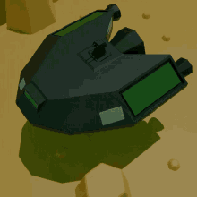 a black object with a green screen sits on a sandy surface