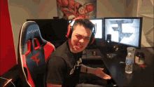 a man wearing headphones is sitting in a gaming chair with the letter f on the back