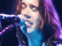a close up of a woman singing into a microphone .
