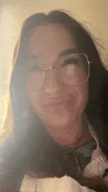 a close up of a woman wearing glasses and making a face .