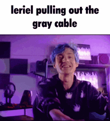 a man with blue hair is smiling while pulling out a gray cable