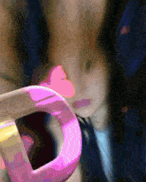 a woman 's face is visible behind a pink object