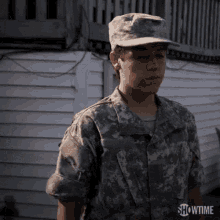 a young man in a military uniform is standing in front of a white house with showtime written on the bottom