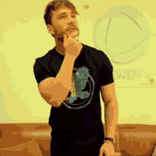 a man with a beard is wearing a black t-shirt with an eagle on it
