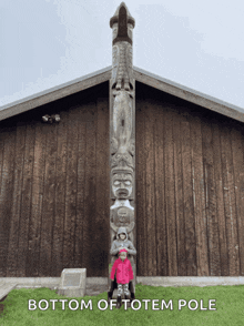 a little girl stands in front of a totem pole with the words bottom of totem pole below her