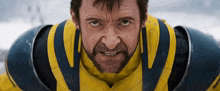 a man with a beard is wearing a yellow and blue armored suit .