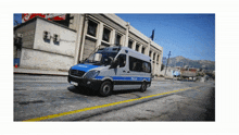 a police van drives down a street in front of a building