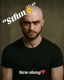 a bald man with a beard is wearing a black t-shirt and making a funny face .