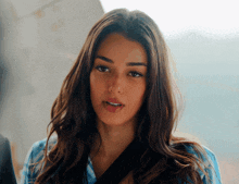 a woman with long dark hair and a nose ring
