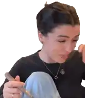 a woman wearing a black sweater and a necklace with a letter o on it