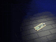 a small electronic device is laying on a black tiled floor