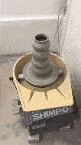 a shimpo pottery wheel with a clay pot on it
