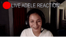 a woman wearing headphones is smiling in front of a live adele reaction