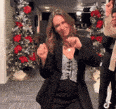 a woman dancing in front of a christmas tree with a tiktok icon