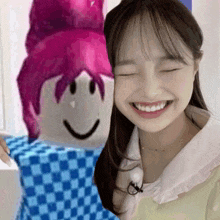 a girl with pink hair is smiling next to a roblox character with a smiley face .