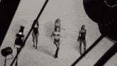 three women in lingerie are dancing in a black and white photo