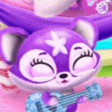 a purple stuffed animal with a star on its head is holding a guitar