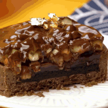 a piece of chocolate cake on a white plate with gold foil on top