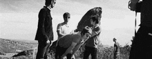 a group of men are standing on top of a hill .