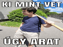 a man holding a wooden stick with the words ki mint vet ugly arata