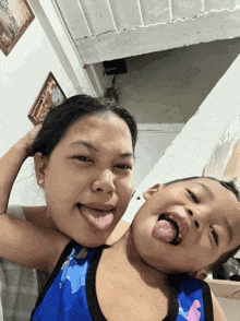 a little boy sticking his tongue out next to a woman