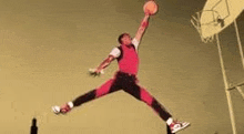 a basketball player is jumping in the air while holding a basketball .