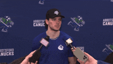a man wearing a blue shirt that says abbotsford canucks