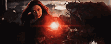 scarlet witch is holding a red light in her hand in the avengers : endgame .