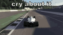 a white race car is driving down a race track with the words cry about it above it