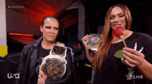 two women holding wrestling championship belts and a rose in front of a screen that says wweraw