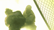 a chain link fence with a shadow of a person