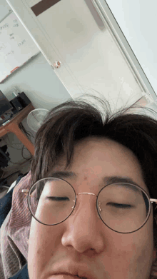 a man wearing glasses is making a funny face