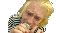 a blonde man singing into a microphone with a striped shirt on